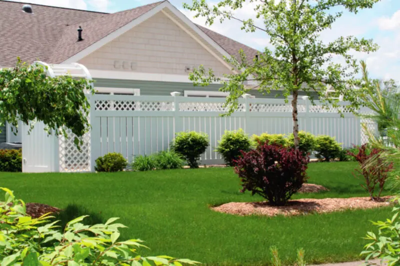 White fence lush green lawn