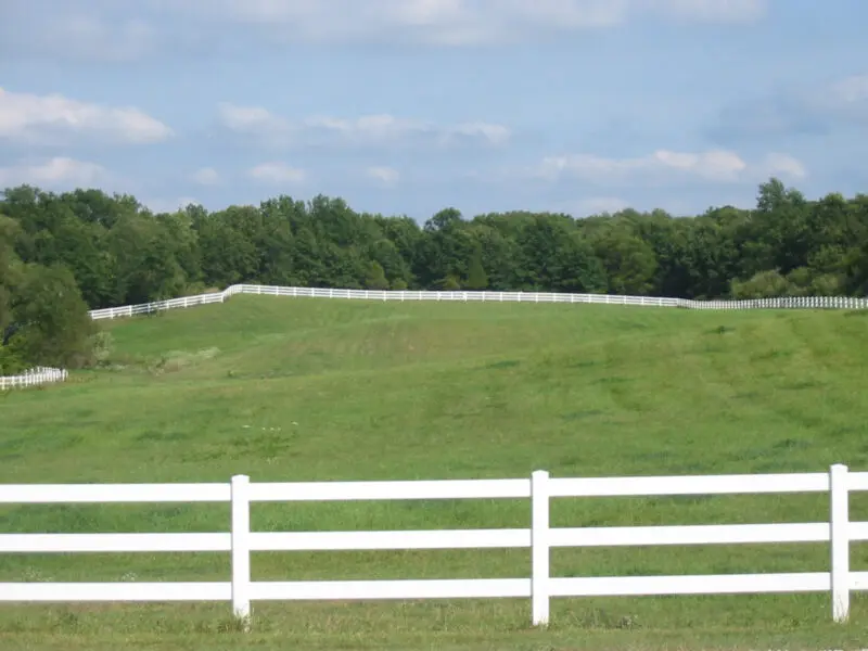 White fence surrounding green field
